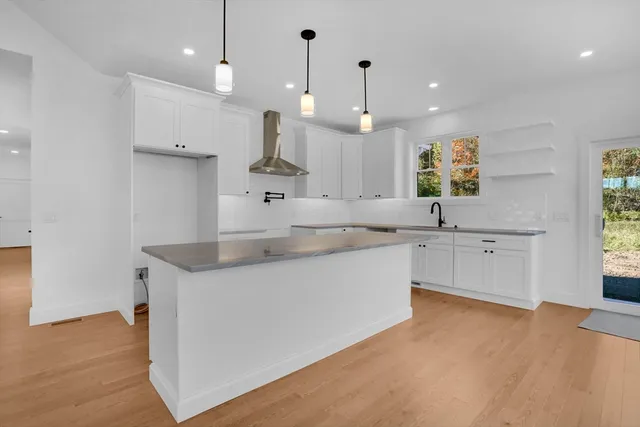 a large kitchen with stainless steel appliances a large counter top a sink a window and a refrigerator