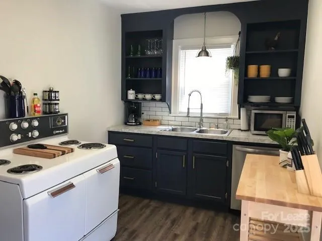 a kitchen with a stove a sink and a microwave