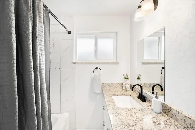 a bathroom with a granite countertop sink