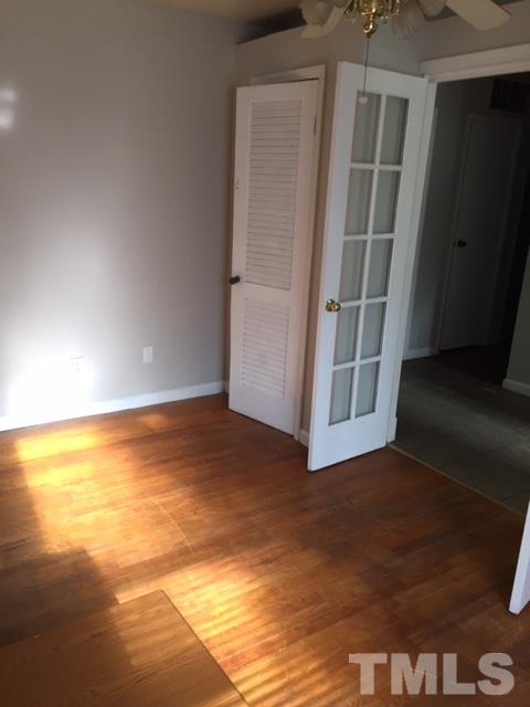 1005 Beverly Drive Raleigh, NC 27610 - Photo 3 of 10 a view of an empty room with wooden floor and a window
