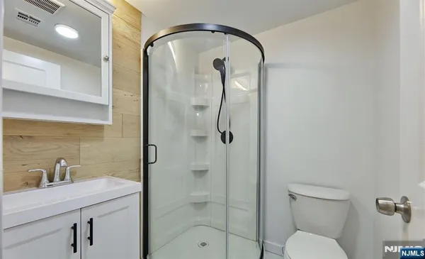 a bathroom with a granite countertop sink a toilet and shower