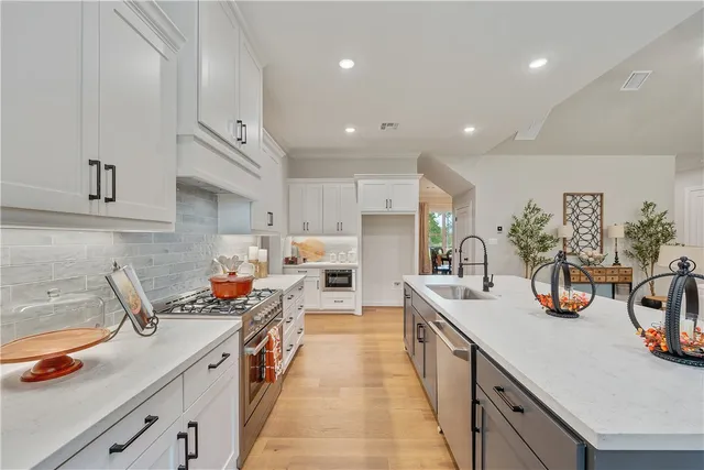a kitchen with sink a stove and cabinets