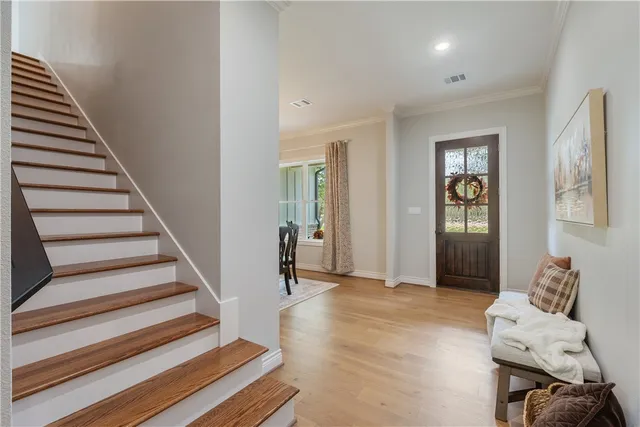 a view of a hallway with wooden floor and stairs