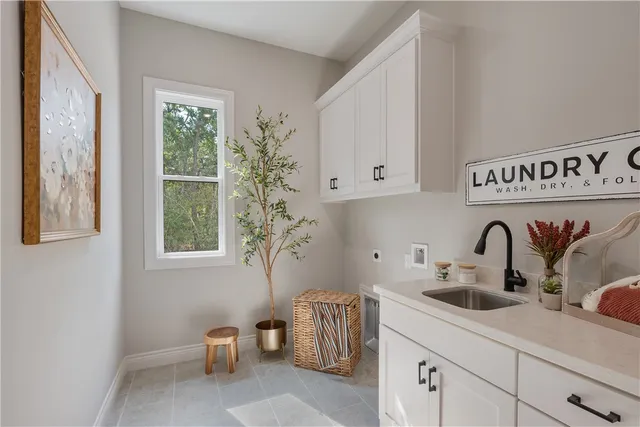 a kitchen with stainless steel appliances a sink a stove and white cabinets