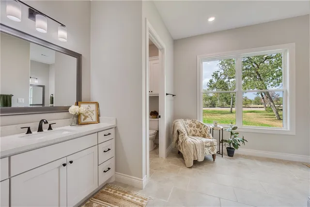 a en suite bathroom with a double vanity sink and a window