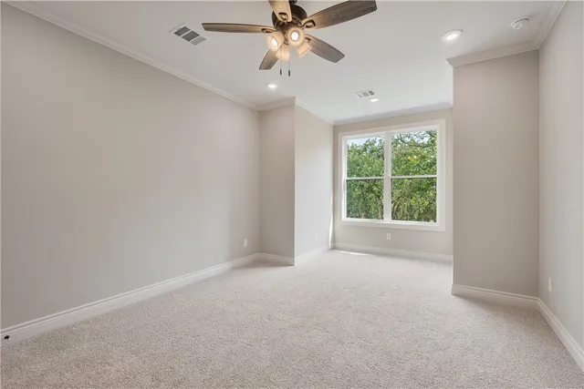 en empty room with windows and ceiling fan