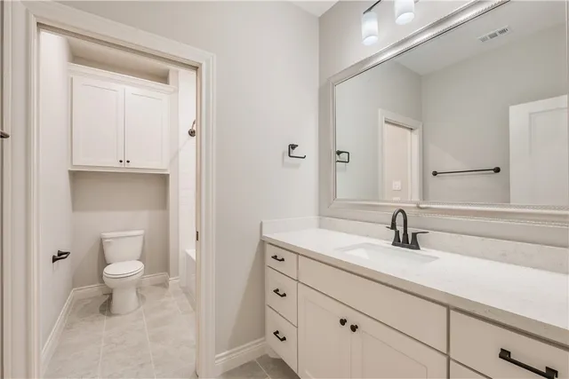 a bathroom with a toilet a sink and a mirror