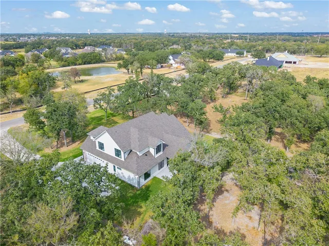 an aerial view of a house with a garden and lake view