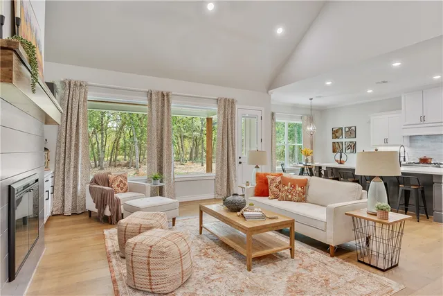 a living room with fireplace furniture and a large window