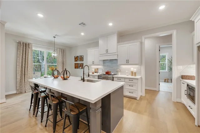 a kitchen with appliances a stove a table and chairs in it