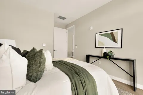 a bedroom with a bed and a painting on the wall