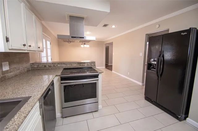 a kitchen with granite countertop a refrigerator and a sink