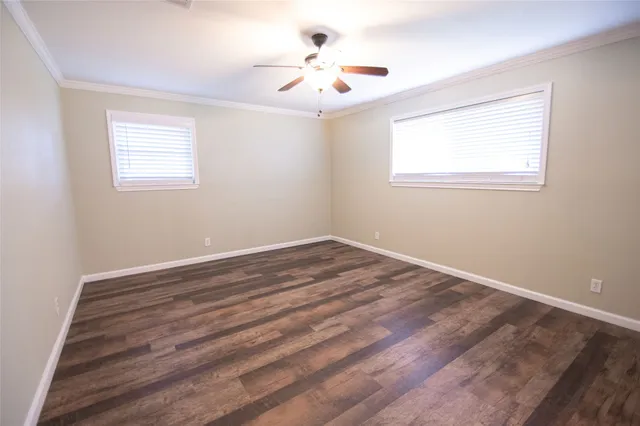 a view of a room with wooden floor and a ceiling fan