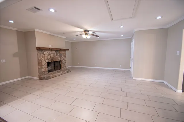 an empty room with windows and fireplace