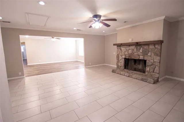 an empty room with windows and fireplace