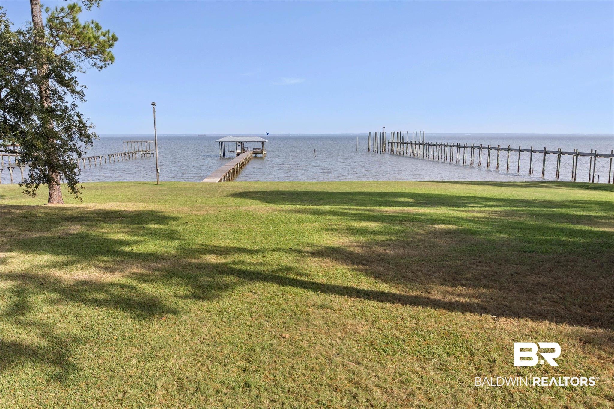 7015 Bay Road Mobile, AL 36605 - Photo 44 of 53 View of green lawn featuring a boat dock and a water view