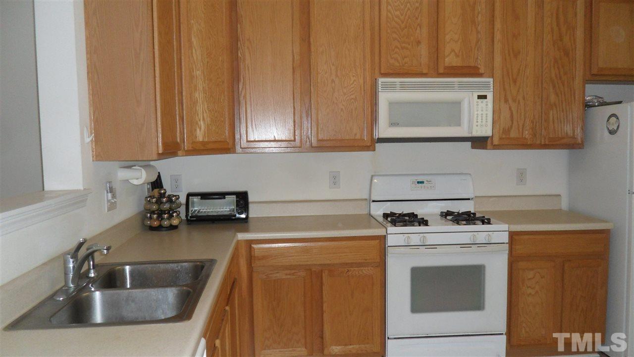 2830-102 Barrymore Street, Unit 102 Raleigh, NC 27603 - Photo 3 of 15 a kitchen with a sink stove and cabinets