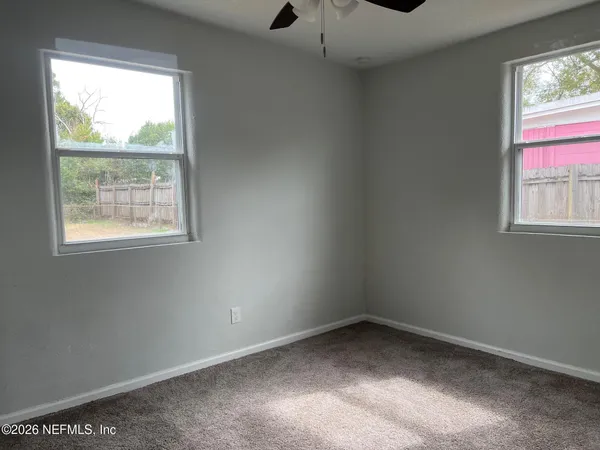 an empty room with windows and closet