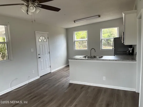a kitchen with granite countertop a sink cabinets and wooden floor