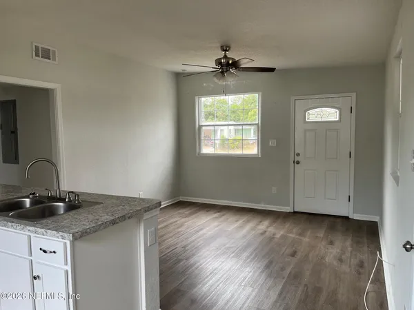 a kitchen with kitchen island granite countertop a sink cabinets and wooden floor