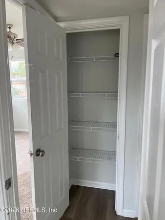 a view of walk in closet with empty racks