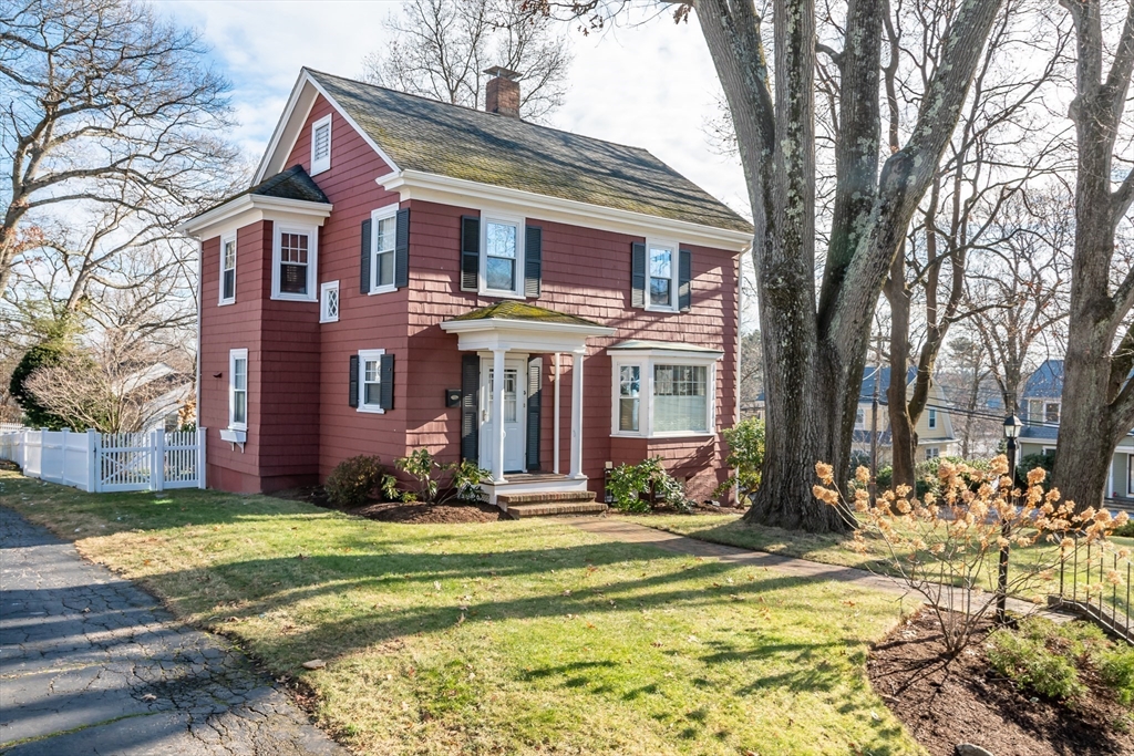 a front view of residential houses with yard and trees
