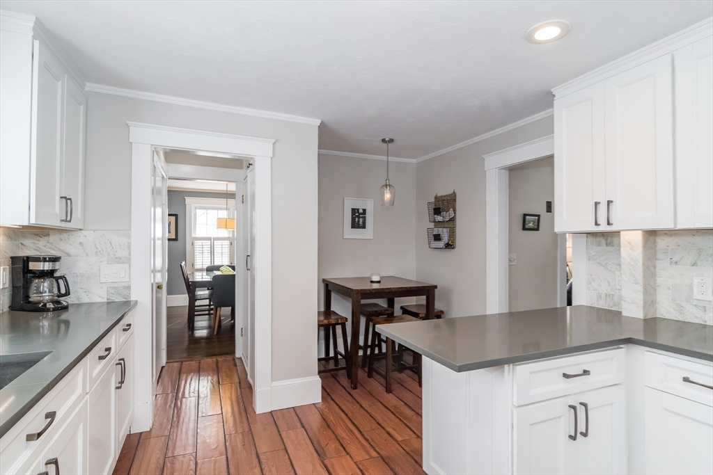 5 Hillcrest Road Framingham, MA 01702 - Photo 10 of 30 a kitchen with granite countertop a table chairs stove and cabinets