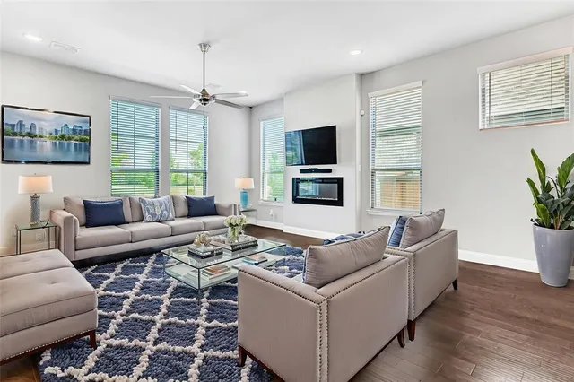 a living room with furniture a flat screen tv and a window