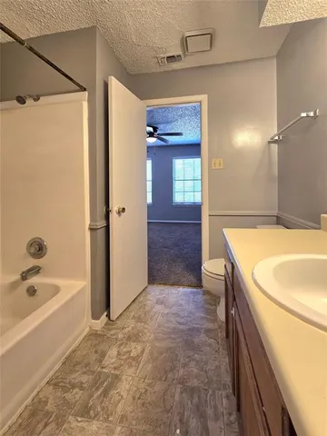 a bathroom with a tub a sink and a large mirror