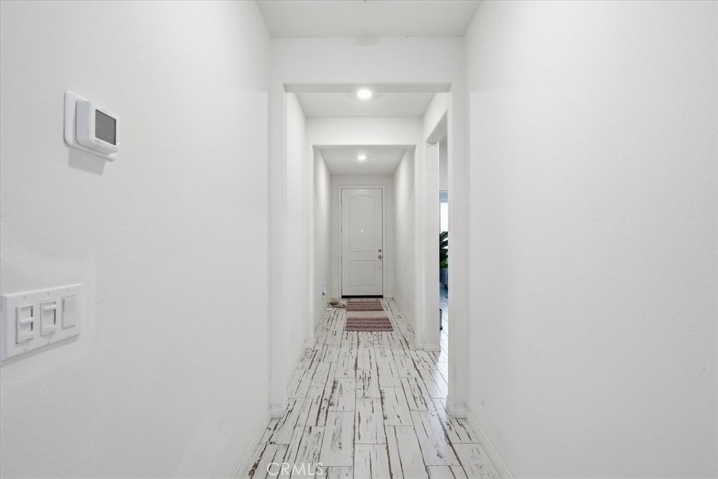32350 Iron Trail Road Winchester, CA 92596 - Photo 14 of 32 a view of a hallway with wooden floor and a bathroom