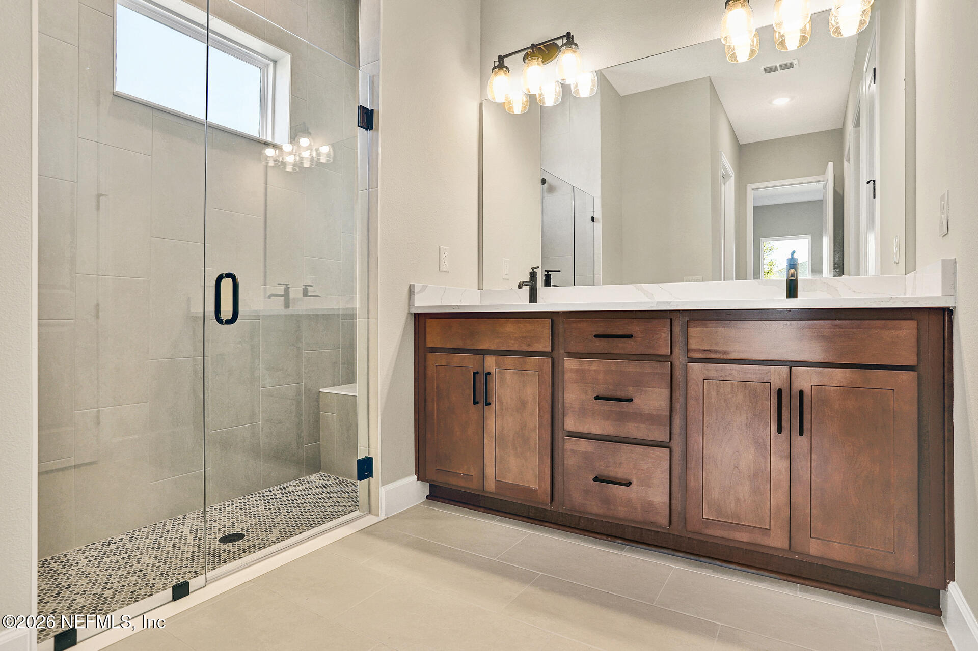 70 Ribera Drive, Unit 323 Flagler Beach, FL 32136 - Photo 15 of 16 a bathroom with a double vanity sink a large mirror and shower