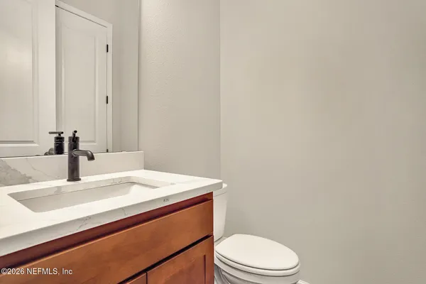 a bathroom with a sink a toilet and mirror
