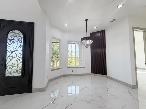 a view of a hallway with a dining table & chairs