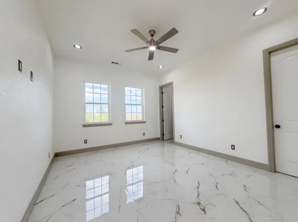 an empty room with wooden floor and mirror