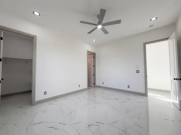 a view of a livingroom with a ceiling fan & window