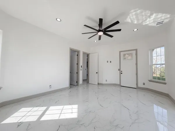 a view of a big room with chandelier fan and windows