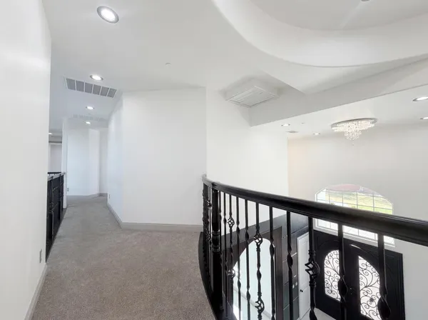 a view of a hallway with wooden floor and windows