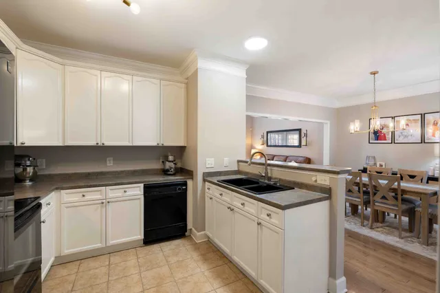 a bedroom with a bed a dresser and a flat tv screen