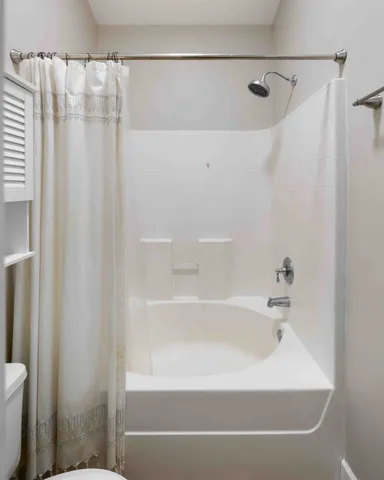 a living room with furniture and two windows