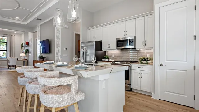 a kitchen with kitchen island granite countertop a sink cabinets and stainless steel appliances