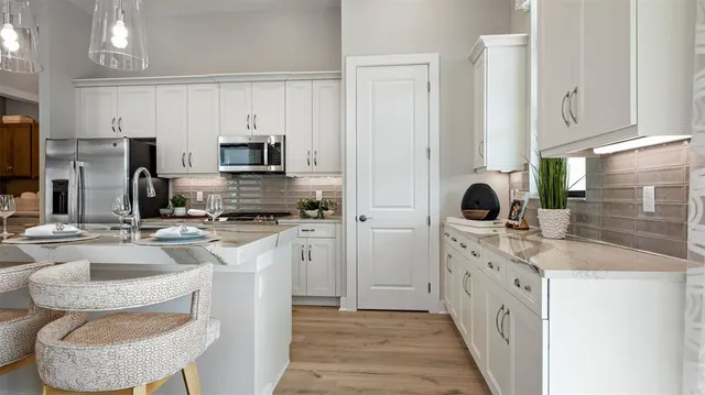 a kitchen with kitchen island granite countertop a sink stove and refrigerator