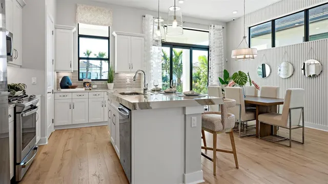 a kitchen with a sink a counter top space stainless steel appliances and a large window