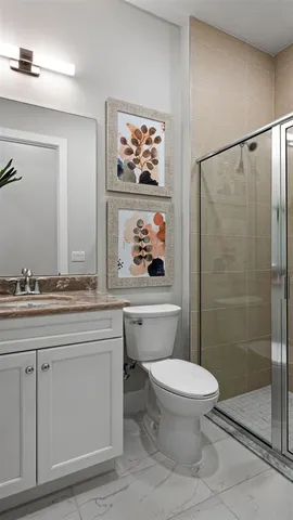 a bathroom with a granite countertop sink a toilet and a shower