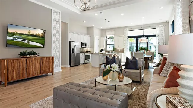 a living room with furniture a flat screen tv and large window