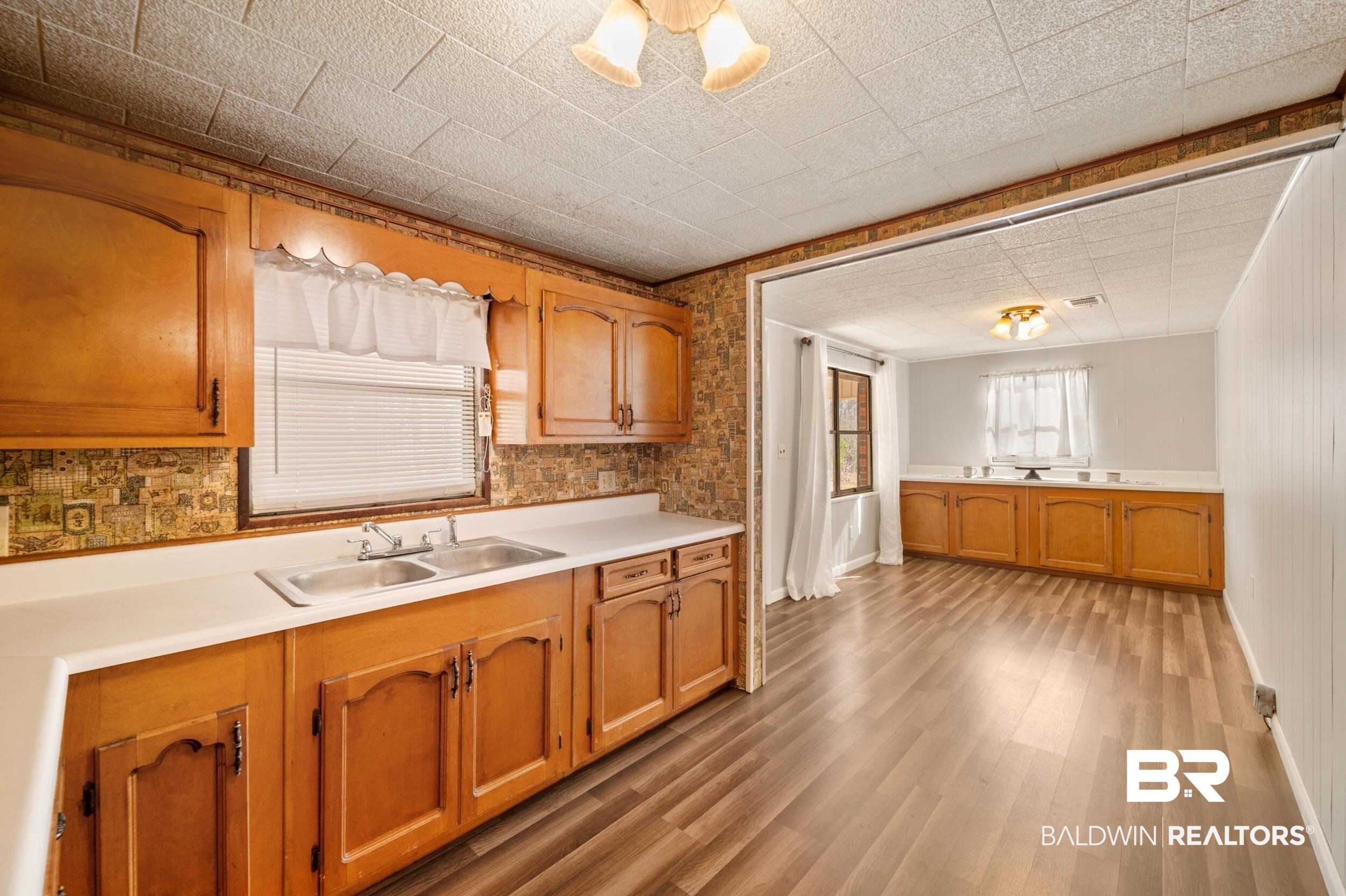 57623 Mary Hadley Road Perdido, AL 36562 - Photo 8 of 34 Kitchen with light countertops, dark wood-style floors, and brown cabinetry