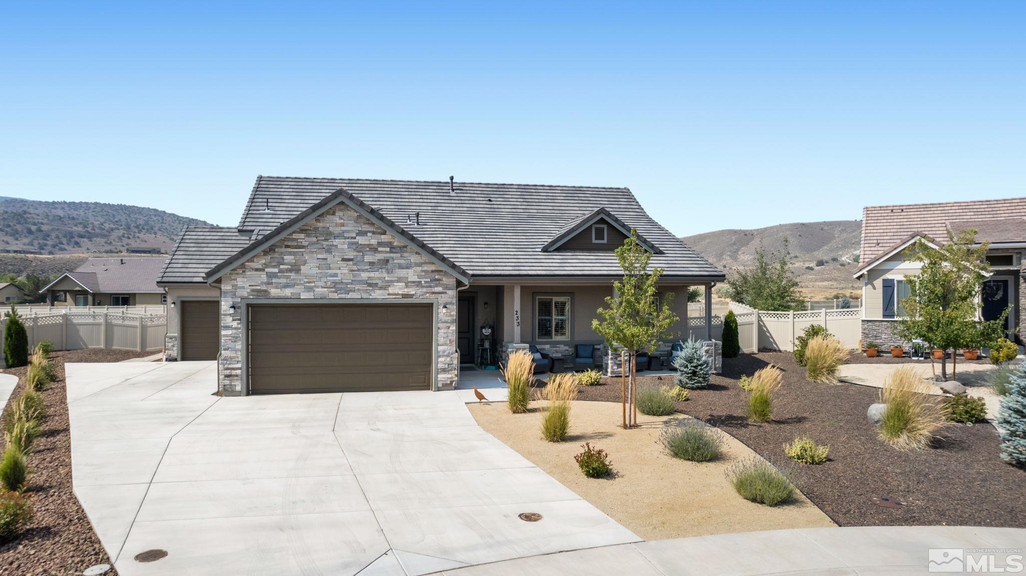 a view of a house with couches potted plants and a floor to ceiling window