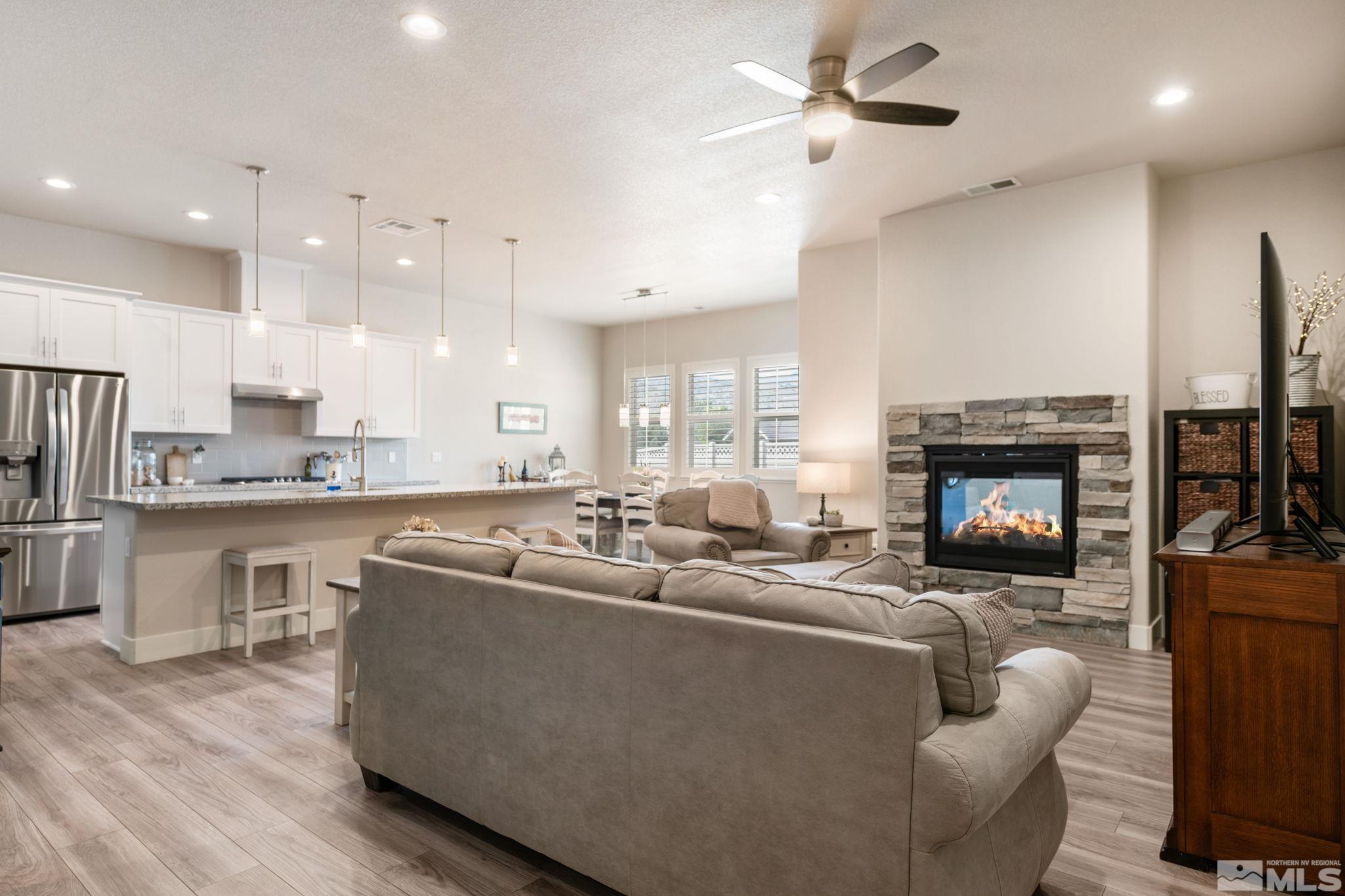 233 Cecina Drive Dayton, NV 89403 - Photo 11 of 39 a living room with stainless steel appliances furniture a fireplace a rug and a window