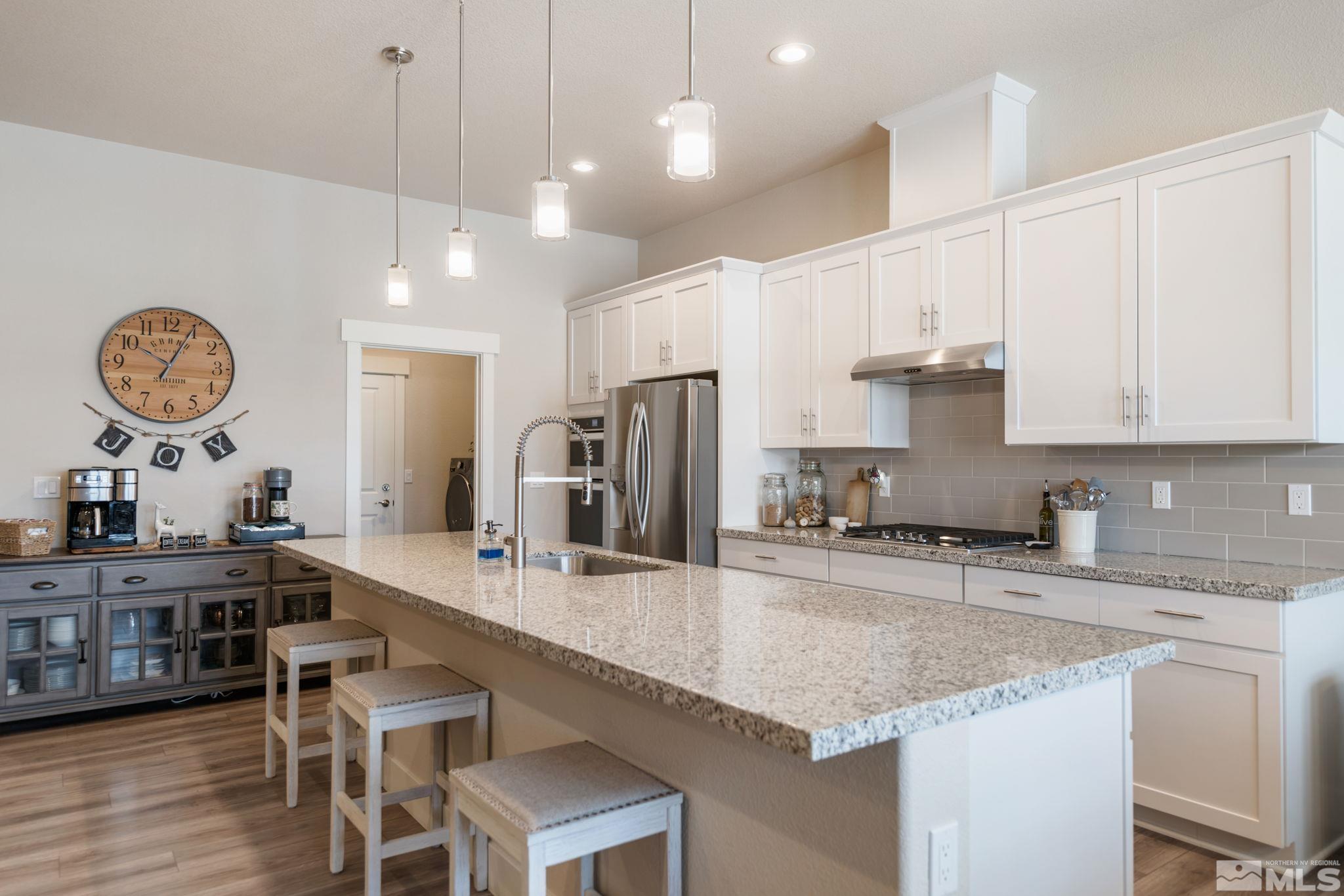 233 Cecina Drive Dayton, NV 89403 - Photo 13 of 39 a kitchen with granite countertop a sink a stove a dining table and chairs