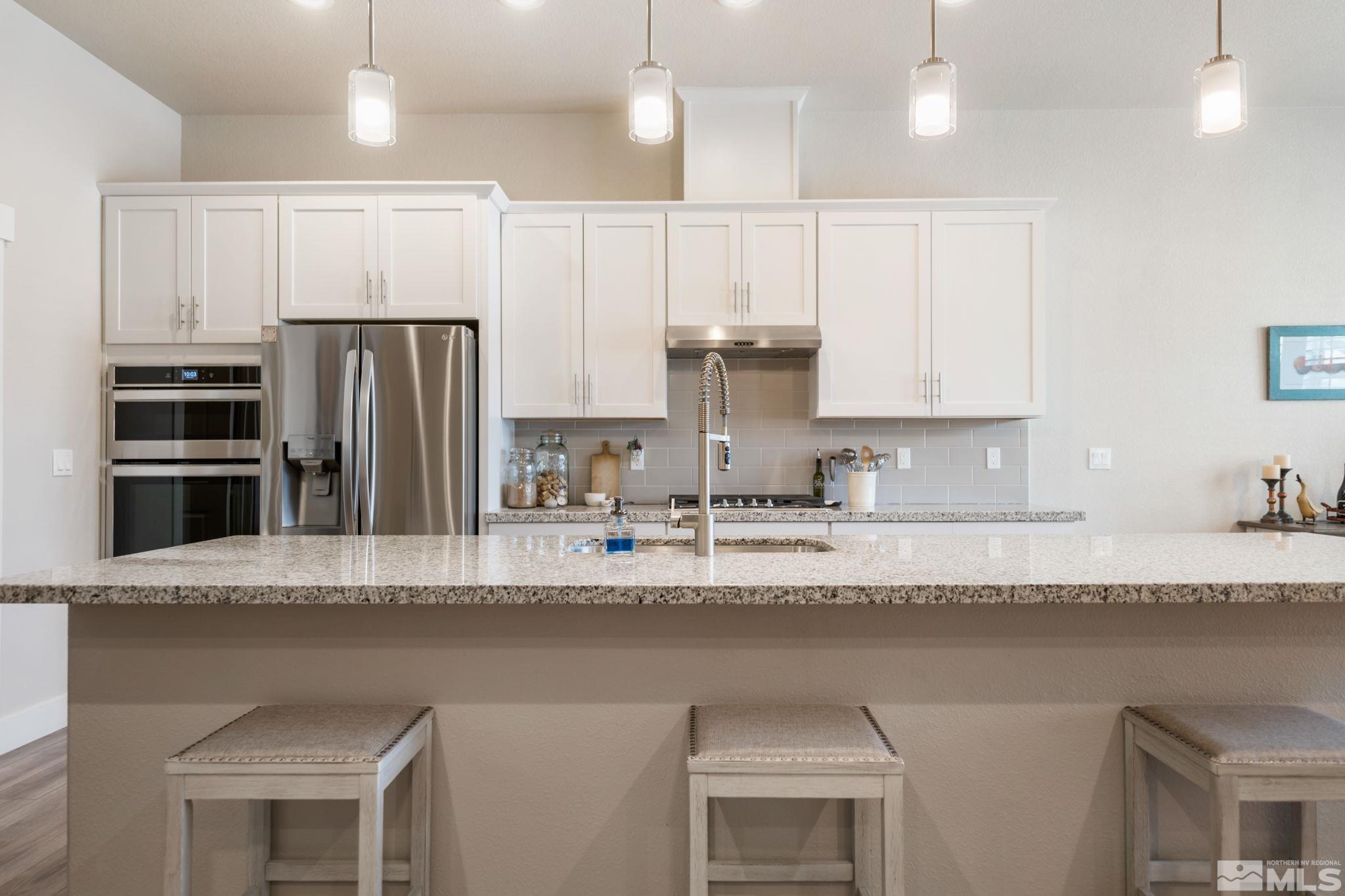 233 Cecina Drive Dayton, NV 89403 - Photo 14 of 39 a kitchen with stainless steel appliances granite countertop a sink refrigerator and cabinets