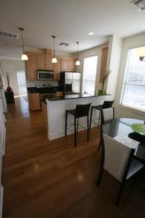 13420 Lyndhurst Street, Unit 401 408 303 Austin, TX 78717 - Photo 12 of 36 a kitchen with stainless steel appliances kitchen island granite countertop a stove a refrigerator a sink a dining table and chairs with wooden floor